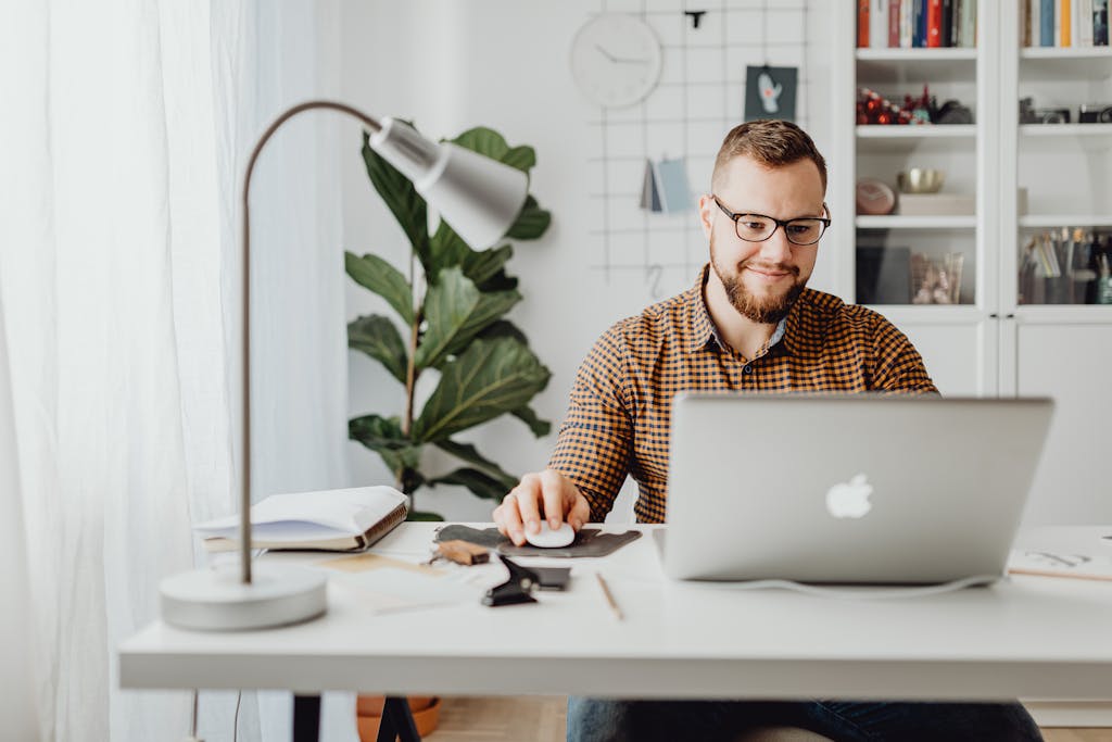 Adult male working remotely in a stylish home office with a laptop, displaying a modern workspace.